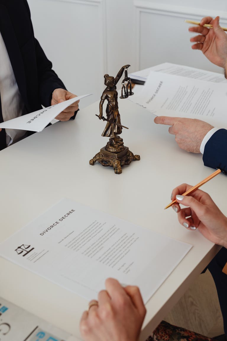 Three professionals reviewing divorce papers in a law office setting.