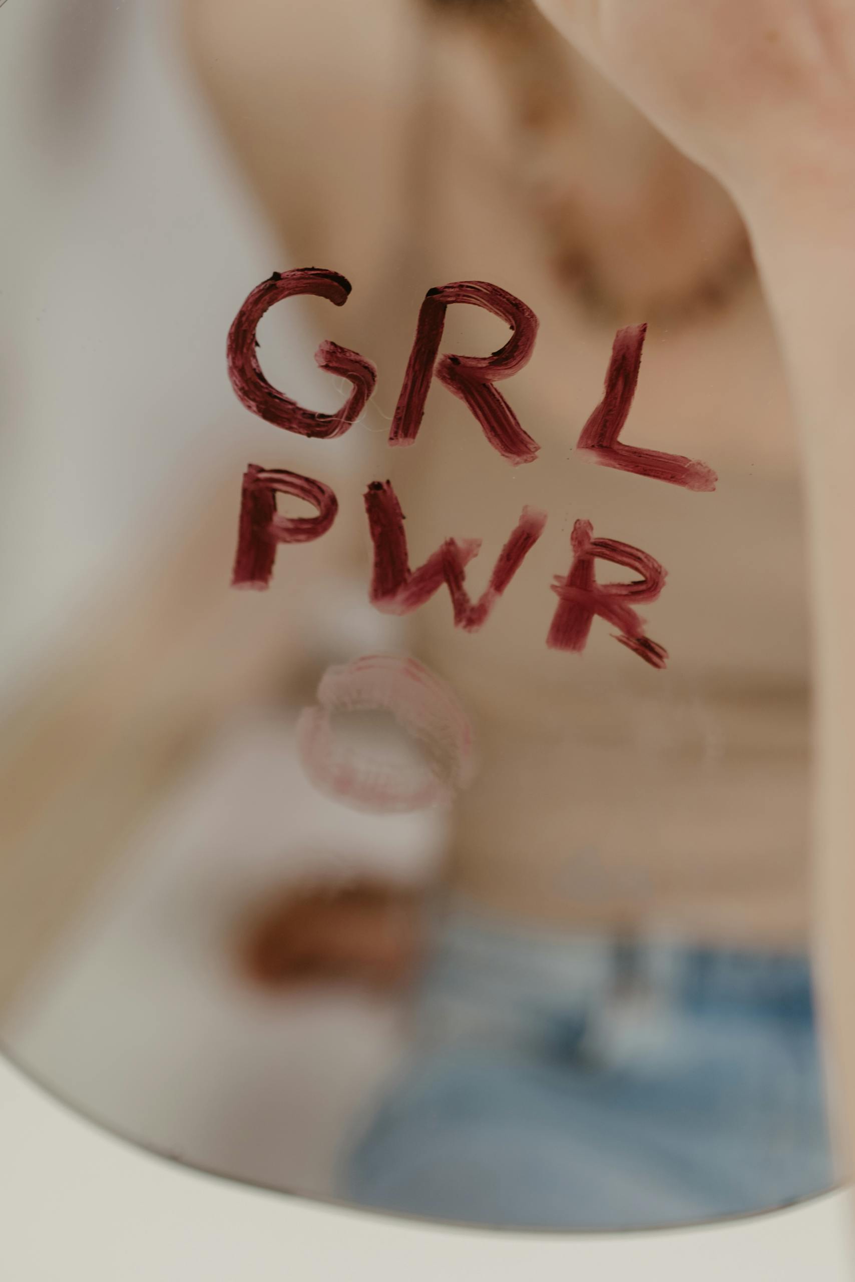 Close-up of 'GRL PWR' written on a mirror with empowering vibe.