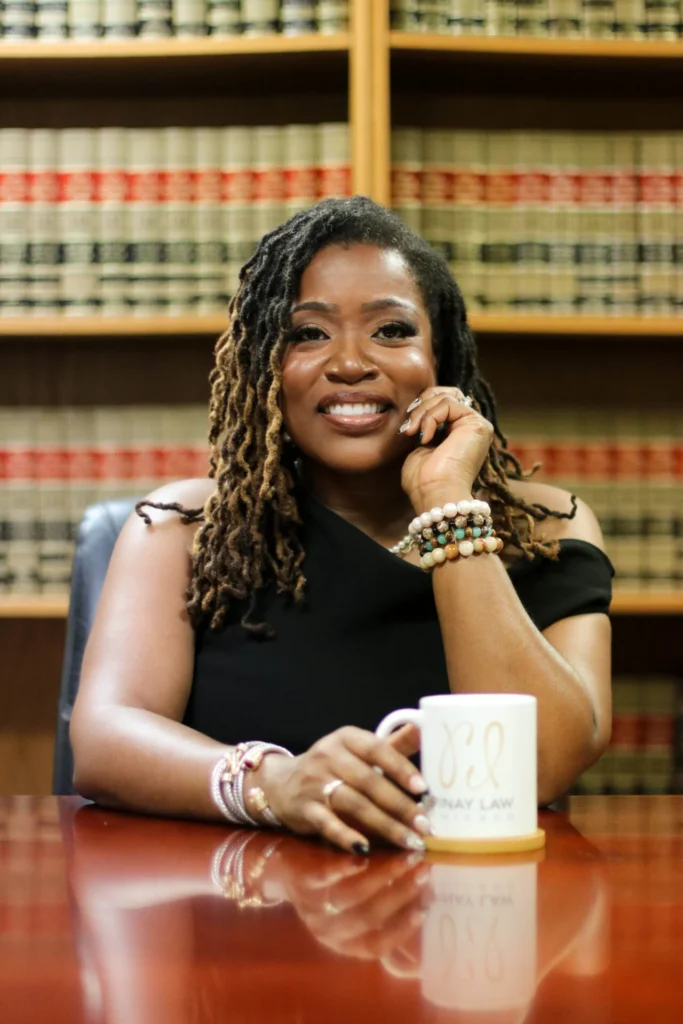 Photo of attorney in conference room in front of law books.