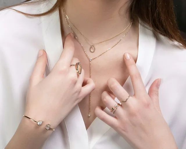 Woman wearing gold necklaces, rings, and bracelets, illustrating jewelry that may be addressed in a prenuptial agreement.